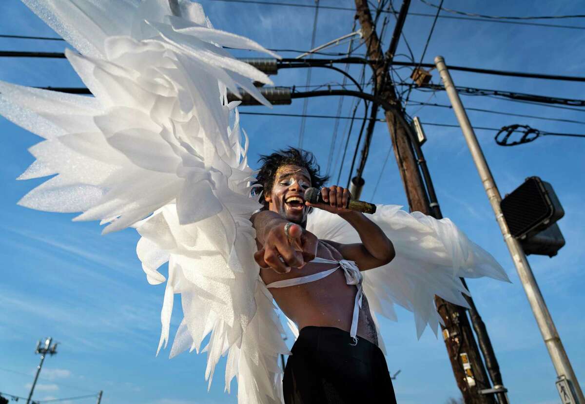 Wearing a pair of white wings, Dimitri Reeves performs at the intersection of Lockwood Drive and Calvalcade Street, Thursday, March 3, 2022, in Houston. Reeves, who is originally from Maryland, has been traveling the country performing on street corners. On any given day since arriving in October, Reeves could be found at intersections around Houston.