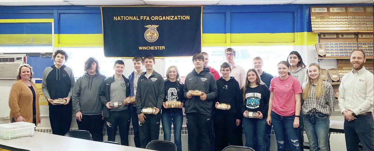 The Winchester FFA chapter recently celebrated National FFA Week and Farmers State Bank of Pittsfield helped in the effort, delivering doughnuts to club members in recognition of the occasion. Making the delivery were Nichole Mason (left), bank vice president; and Bryan Hubbert (right), the bank's vice president for commercial lending.