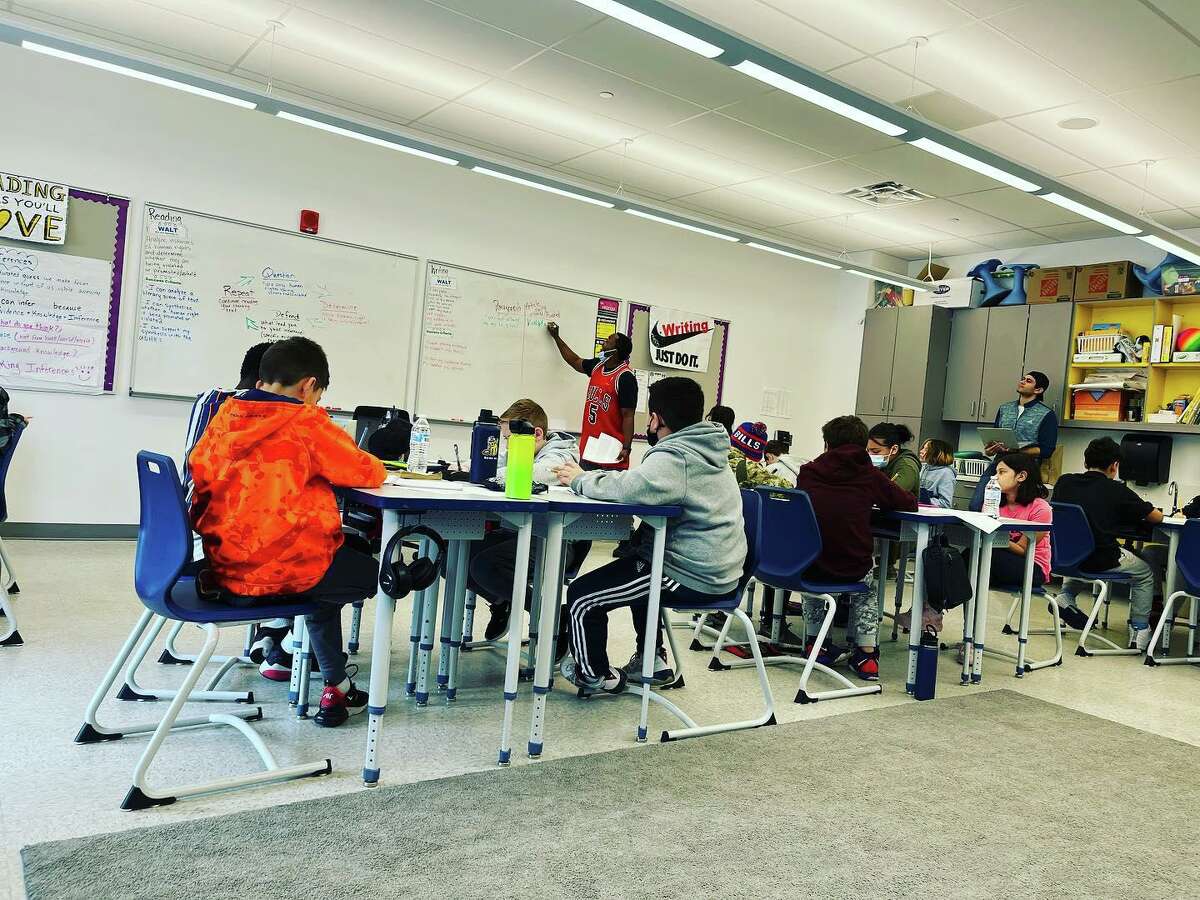 A photo of a fifth-grade classroom at Johnson Elementary School in Bethel, Conn. shows students and staff with and without masks.