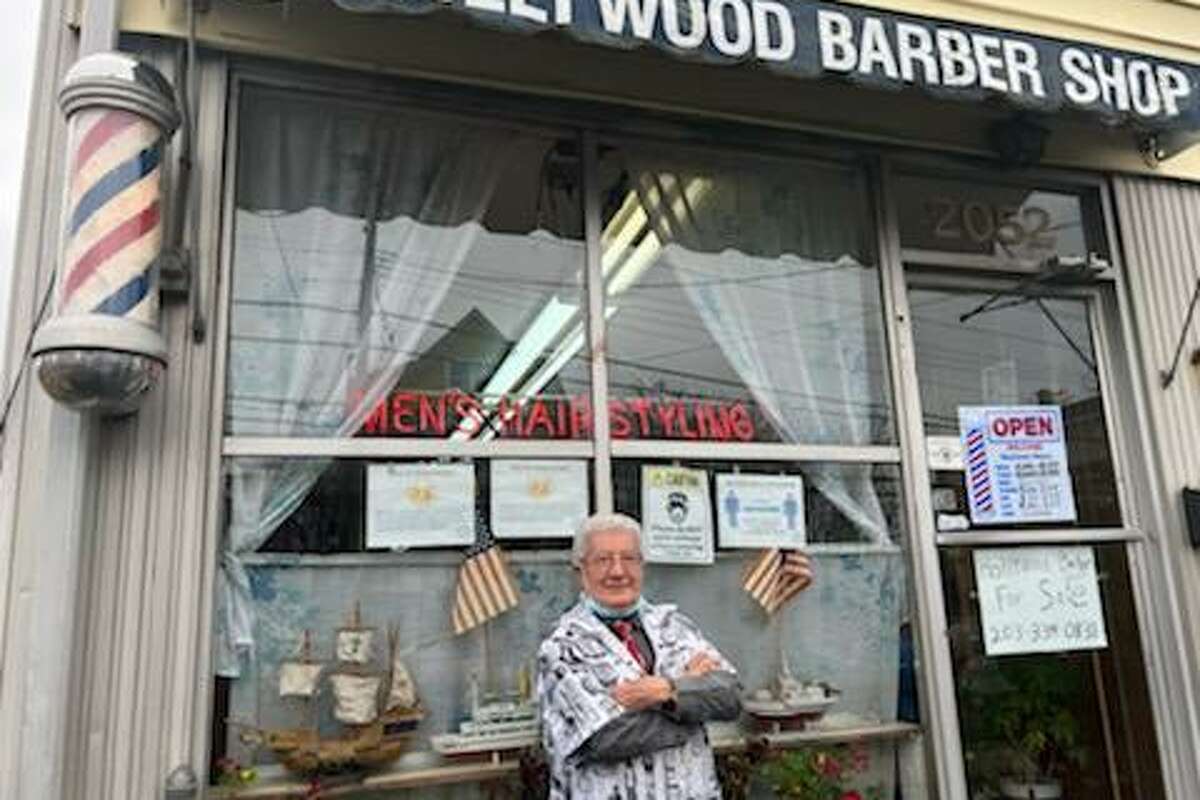 Gaetano “Guy” Camagna in front of his Hollywood Barber Shop on East Main Street in Bridgeport, which he ran for more than 50 years before retiring last month.