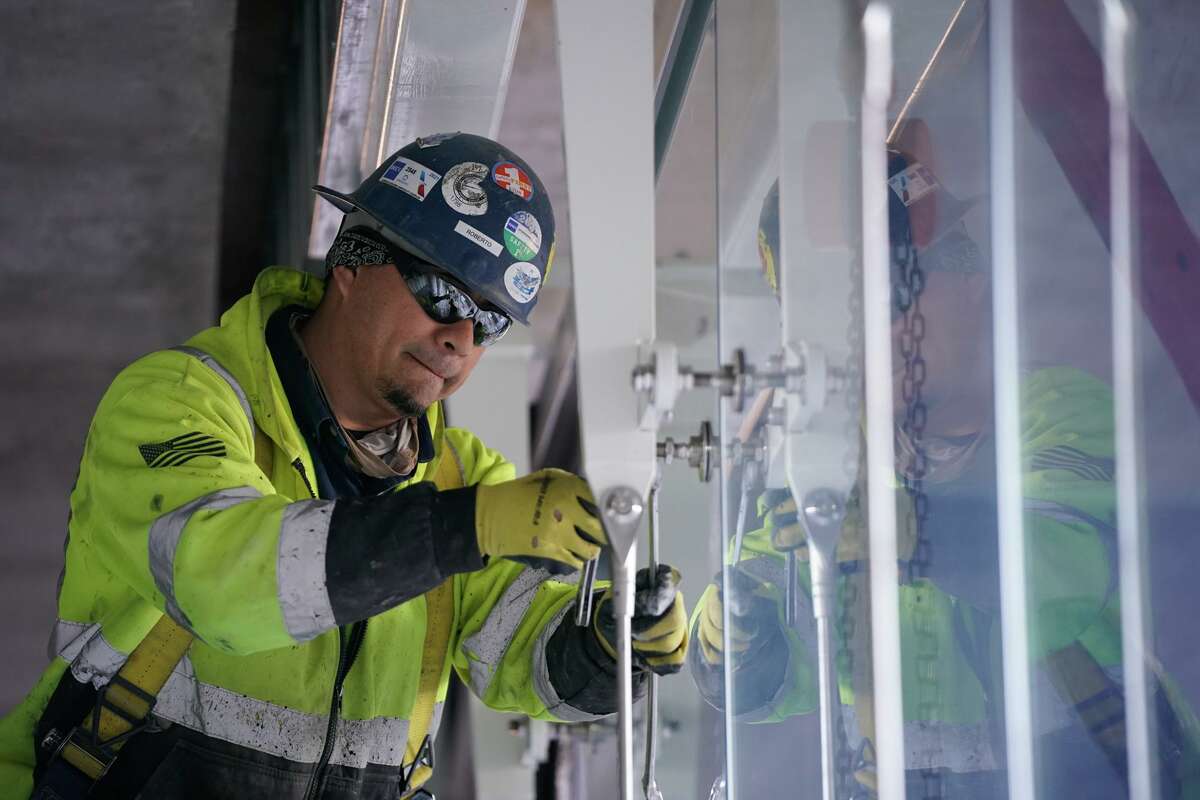 Workers install glass panels at University Health Woman’s and Children’s Hospital. The 12-story, 300-bed hospital for women, babies and children also features a 900-space parking garage.