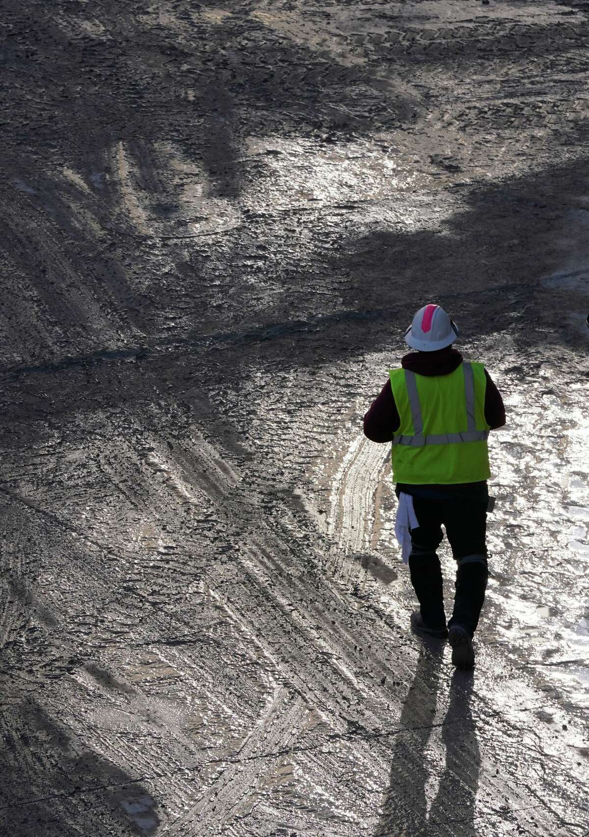 A construction worker walks through mud at the site of the University Health’s Woman’s and Children’s Hospital. The 12-story, 300-bed hospital for women, babies and children also features a 900-space parking garage.