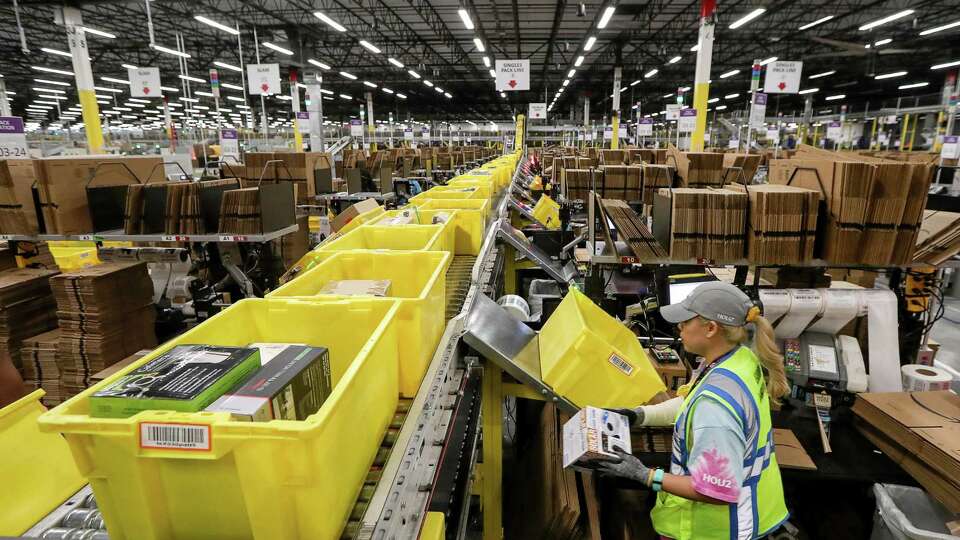 An associate packs boxes at an Amazon fulfillment center in Houston. The company announced partnerships with nine Texas colleges to provide access to education for hourly employees.