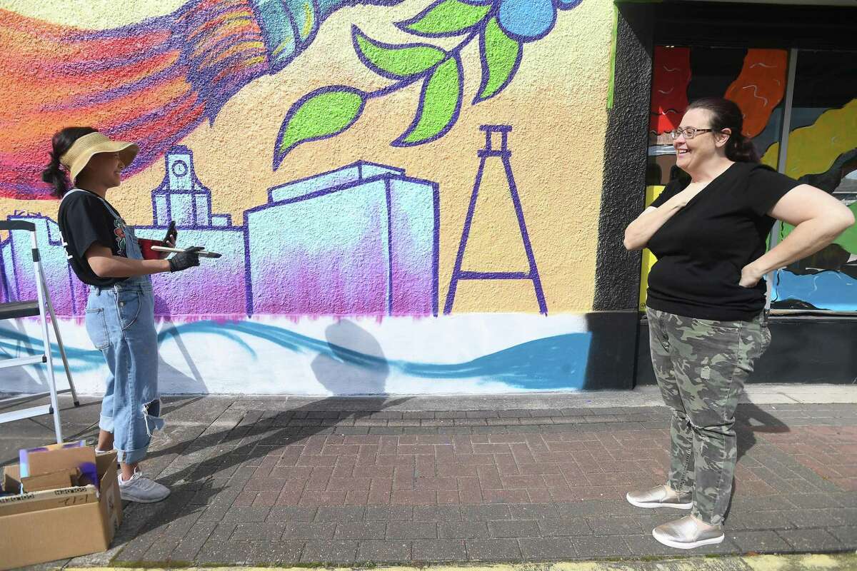 Melissa Londenberg talks with artist Caroline Truong as she continues her piece at MAKE Creative Space on Calder Avenue for this weekend's inaugural Mural Fest in Beaumont. Photo made Friday, March 4, 2022 Kim Brent/The Enterprise