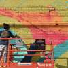 Artists work in the alleway outside the festival hub at 308 Orleans Street in preparation for this weekend's inaugural Mural Fest in Beaumont. Photo made Thursday, March 3, 2022 Kim Brent/The Enterprise