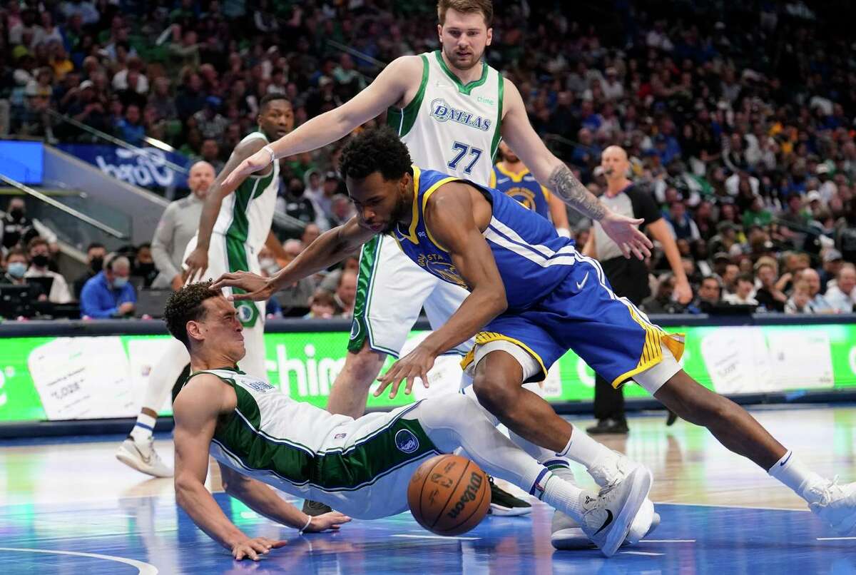 Mavericks center Dwight Powell (left) is knocked to the floor by Warriors forward Andrew Wiggins in the second half of Golden State’s loss on Thursday in Dallas.