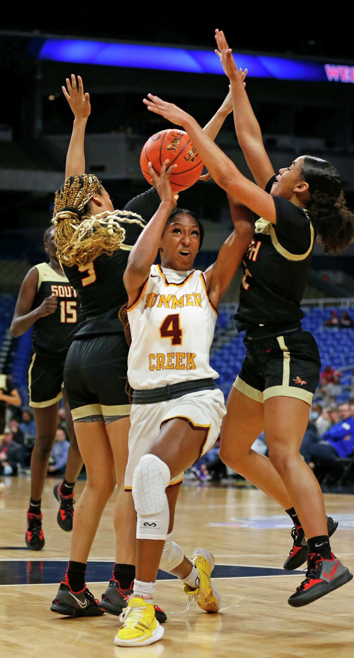 Humble Summer Creek forward Kaitlyn Duhon (4) tries to drive between South Grand Prairie defenders in first half. South Grand Prairie defeated Sunmer Creek 67-41 in UIL Class 6A girls basketball state semifinal on Friday, March 4, 2022 at the Alamodome.