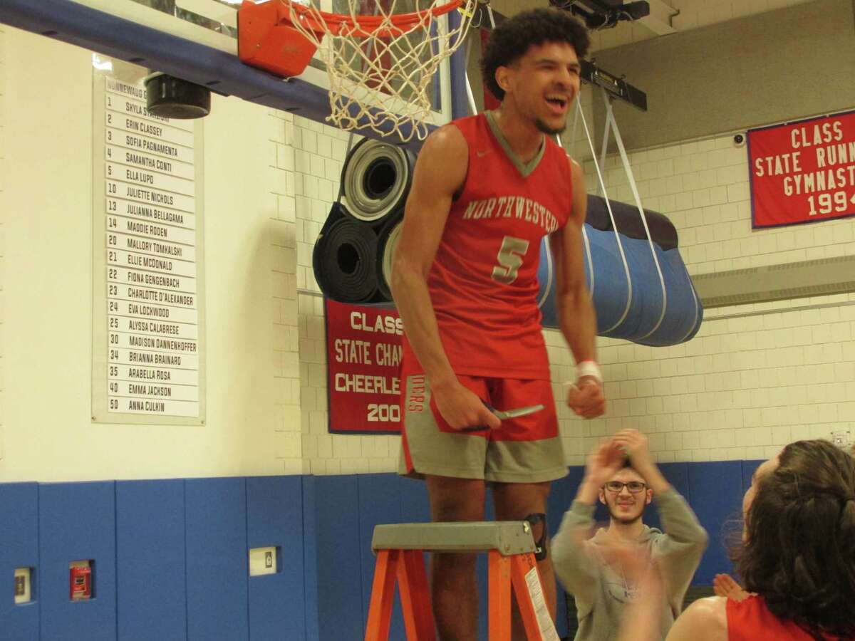 Northwestern high scorer Fred Camp roars at the Highlander crowd after cutting his piece of the net in a Berkshire League Boys Basketball Tournament Championship win over Terryville Friday night at Nonnewaug High School.