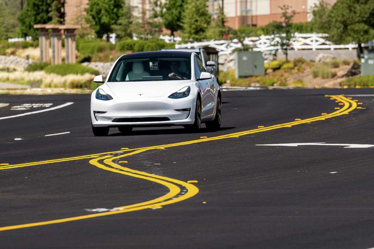 A Tesla Model 3 travels on a road in Rocklin, Calif., on July 21, 2021.