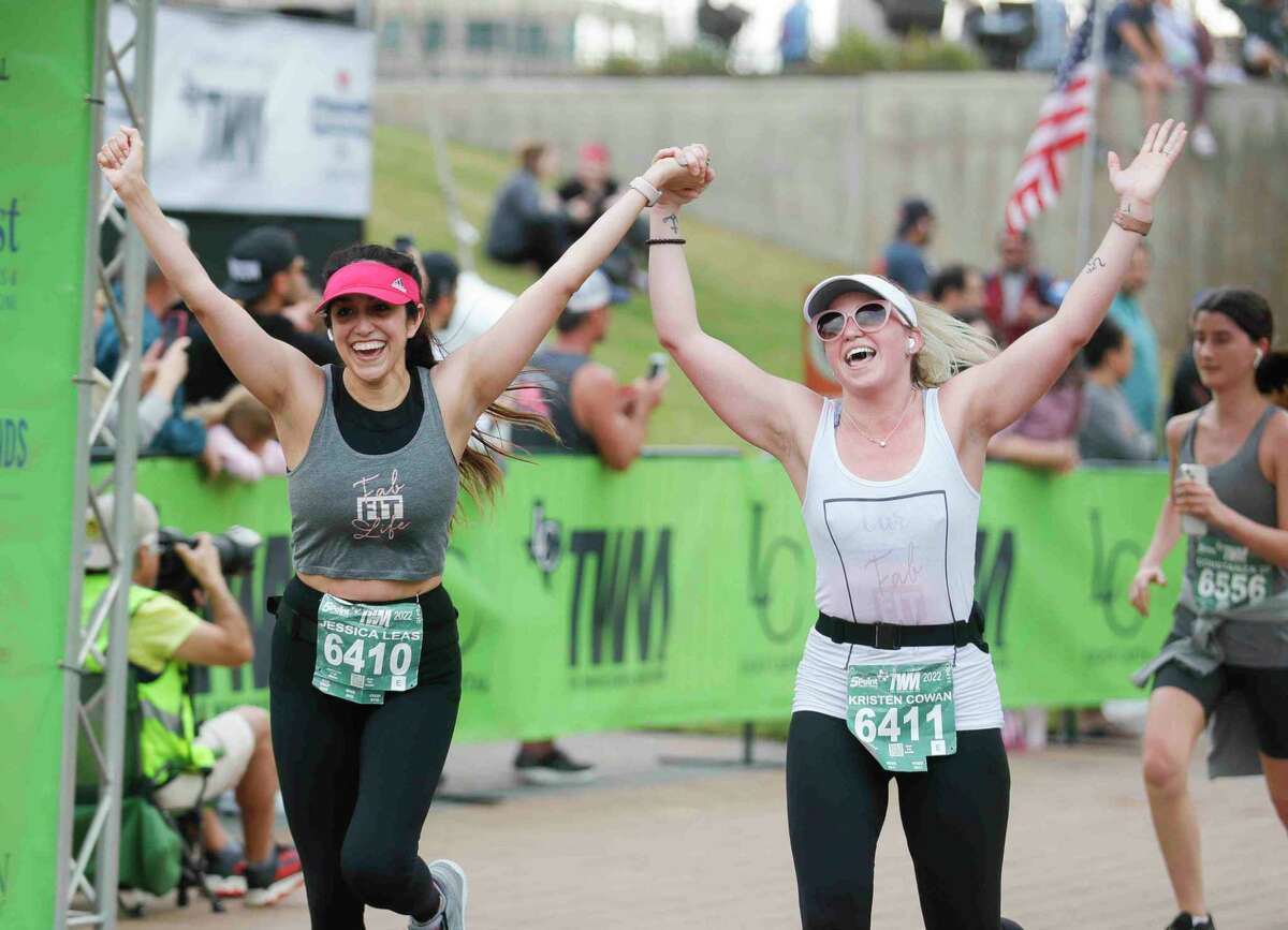 Jessica Leas, left, reacts alongside Kristen Cowan after taking part in The Woodlands Marathon, Saturday in The Woodlands.