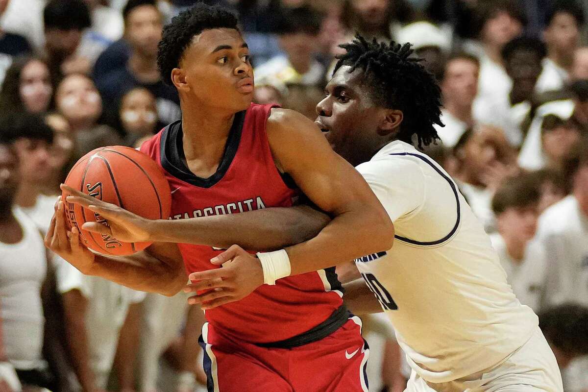 Atascocita guard Angel Johnson, left, looks to pass as Clements forward Chuks Egbo defends during the second half of a Region III-6A semifinal high school basketball playoff game, Friday, March 4, 2022, in Cypress, TX.