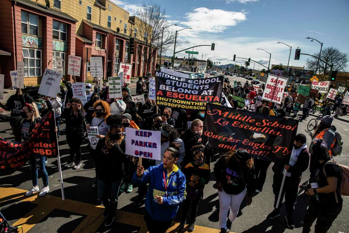 Demonstrators march on International Boulevard against the Oakland Unified School District’s plan to close schools on March 5, 2022.