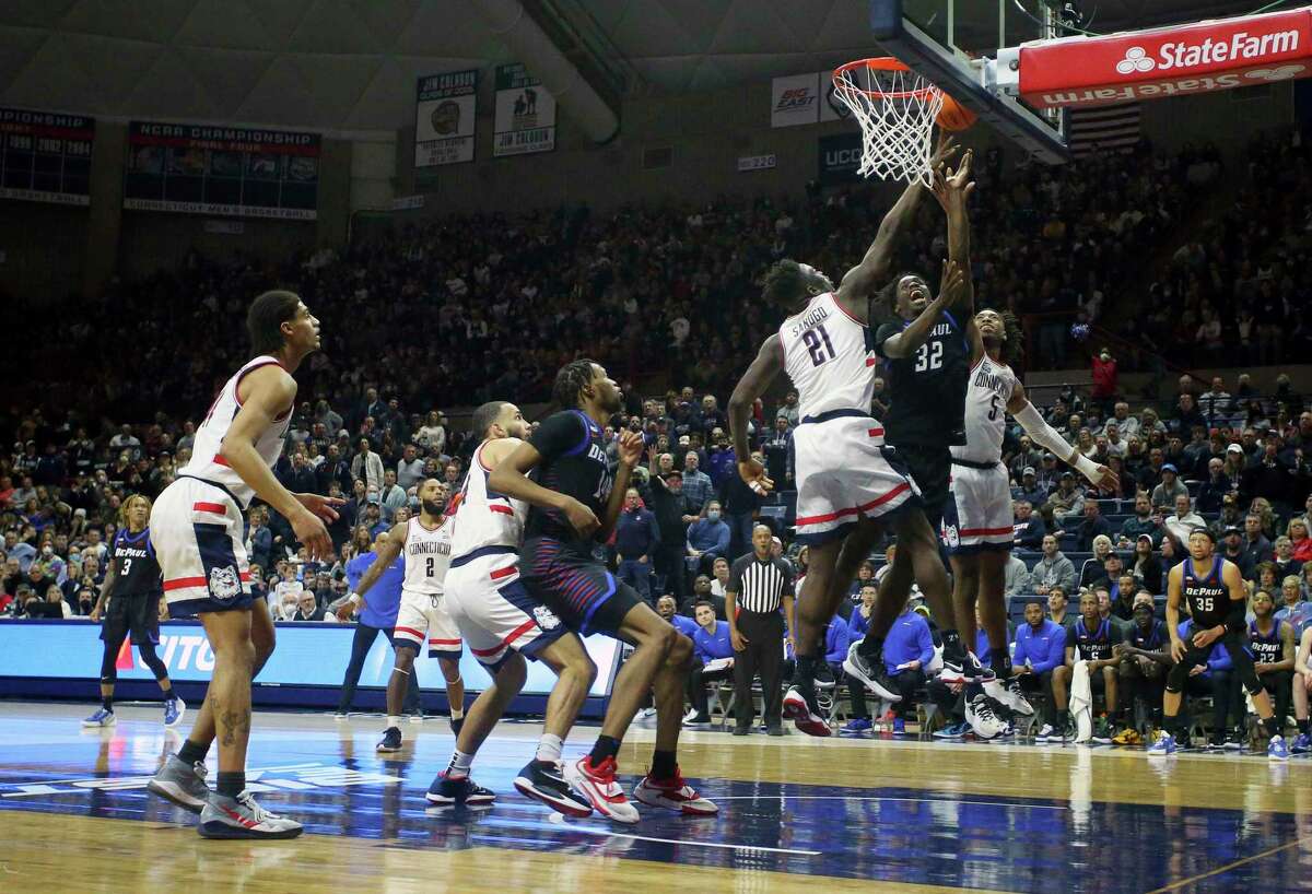 DePaul's David Jones (32) shoots past the defense of Connecticut's Adama Sanogo (21) and Isaiah Whaley (5) during the second half of an NCAA college basketball game Saturday, March 5, 2022, in Storrs, Conn. (AP Photo/Stew Milne)