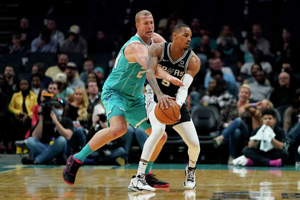 Hornets center Mason Plumlee, left, defends Spurs guard Dejounte Murray during the first half Saturday, March 5, 2022, in Charlotte, N.C.