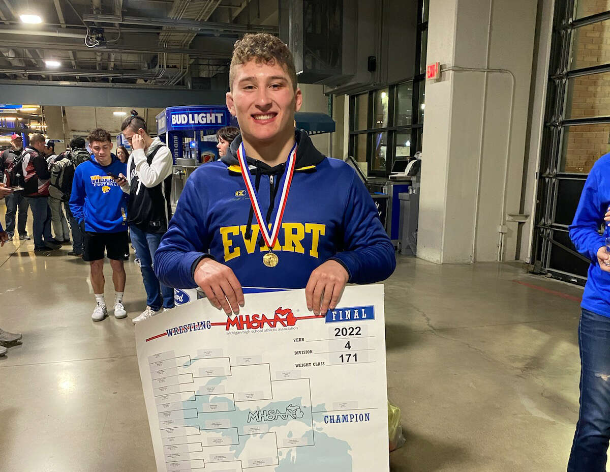 Evart's Cole Hopkins celebrates his state championship in the concourse area at Ford Field on Saturday.