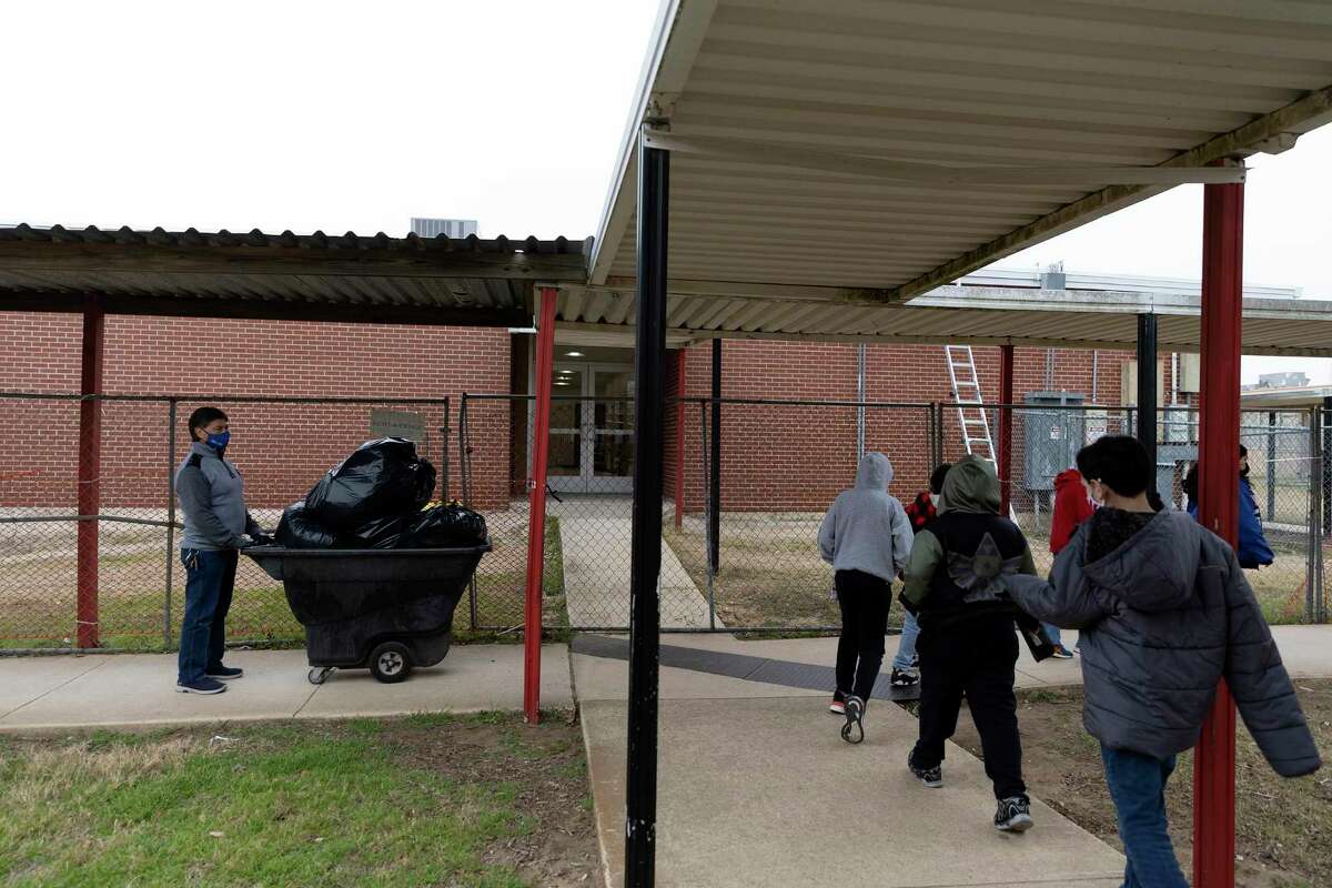 Enrique Moncada waits for students to pass as he takes out trash from the cafeteria to the dumpster. Moncada is the head custodian at Pearce Elementary, and he has worked for the district for 30 years.