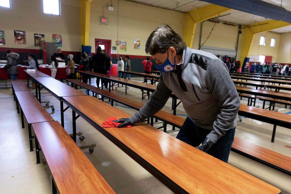 Enrique Moncada wipes down cafeteria tables before the next group of students sit down for lunch. Moncada is the head custodian at Pearce Elementary, and he has worked for the district for 30 years.