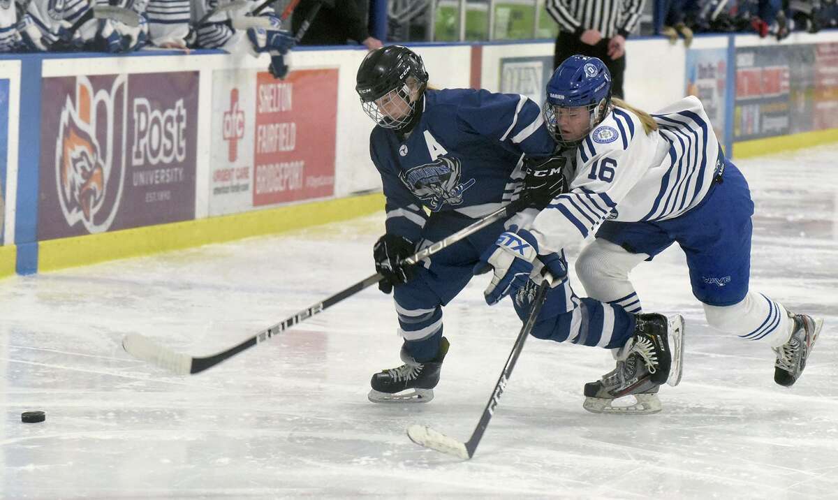 Avon's Bella Bonfiglio (15) and Darien's Gretchen Edwards (16) battle for the puck during the CHSGHA girls ice hockey semifinals in Shelton on Saturday, March 5, 2022. The CHSGHA final between Darien and New Canaan has been moved to the Darien Ice House on Wednesday, to begin at 5:30 p.m.