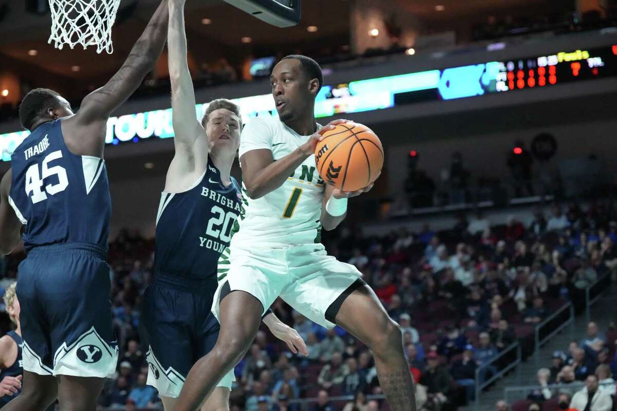 USF's Jamaree Bouyea attempts to pass around BYU's Fousseyni Traore and Spencer Johnson in a WCC tournament  quarterfinal in Las Vegas on Saturday night.