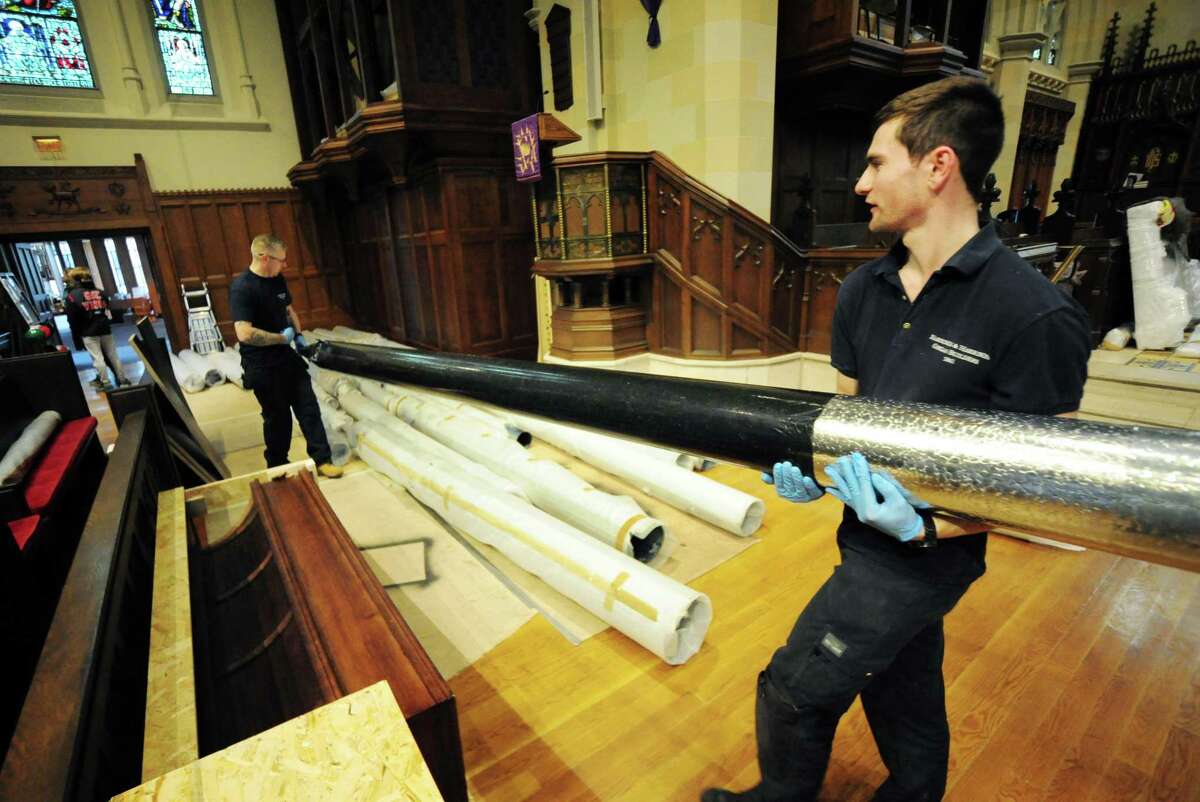 David Beeby, with Harrison and Harrison, carries an organ pipe with fellow worker Rob Newton during a delivery of 4,300 organ pipes and other equipment to Christ Church in Greenwich, Conn., on Saturday March 5, 2022. Harrison and Harrison, established in 1861 in England, is the company that is delivering pipes and redoing the organ.