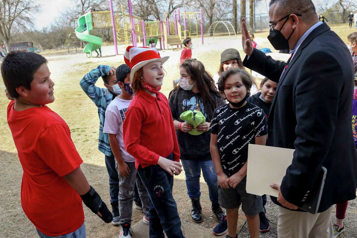 Excited students clamor at Southside ISD Superintendent Rolando Ramirez as he gives them high-fives during his visit to Heritage Elementary School last week. The district’s teacher evaluations rely on more frequent class visits than most. .