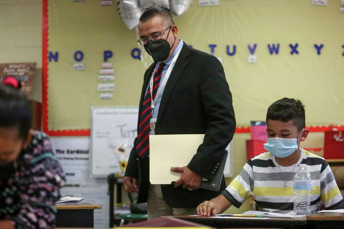 Southside ISD Superintendent Rolando Ramirez looks over the shoulders of students preparing for the STAAR with a mock test at a Heritage Elementary School fifth grade classroom last week. The district’s teacher evaluations rely on more frequent class visits than most. .