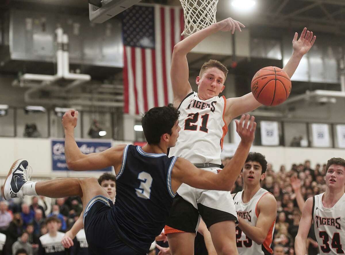 Ridgefield’s Dylan Veillette blocks a shot by Wilton’s Parker Woodring during his team’s victory in the FCIAC championship game Thursday.