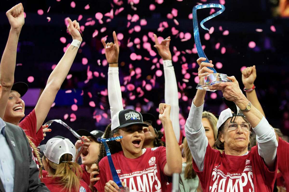 Stanford head coach Tara VanDerveer, right, holds up the winning trophy while her team cheers after they won an NCAA college basketball game for the Pac-12 tournament championship against the Utah Sunday, March 6, 2022, in Las Vegas. (AP Photo/Ellen Schmidt)