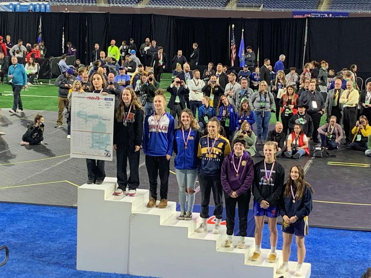 Midland High's Arden Eschtruth (fourth from left) poses on the podium after finishing fourth at 120 pounds in the girls' individual wrestling state final at Ford Field in Detroit on Saturday, March 5, 2022.