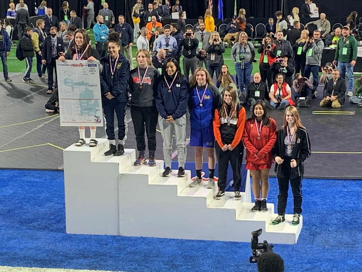Midland High's Morgan Ludwig (fifth from left) poses on the podium after finishing fifth at 145 pounds in the girls' individual wrestling state final at Ford Field in Detroit on Saturday, March 5, 2022.