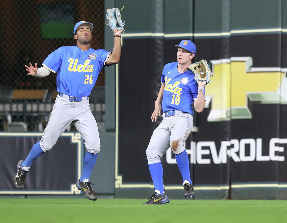 UCLA outfielder Malakhi Knight (24) catches a hit by Texas outfielder Austin Todd (44) in the sixth inning during the Shriners Children's College Classic at Minute Maid Park on Sunday, March 6, 2022 in Houston.