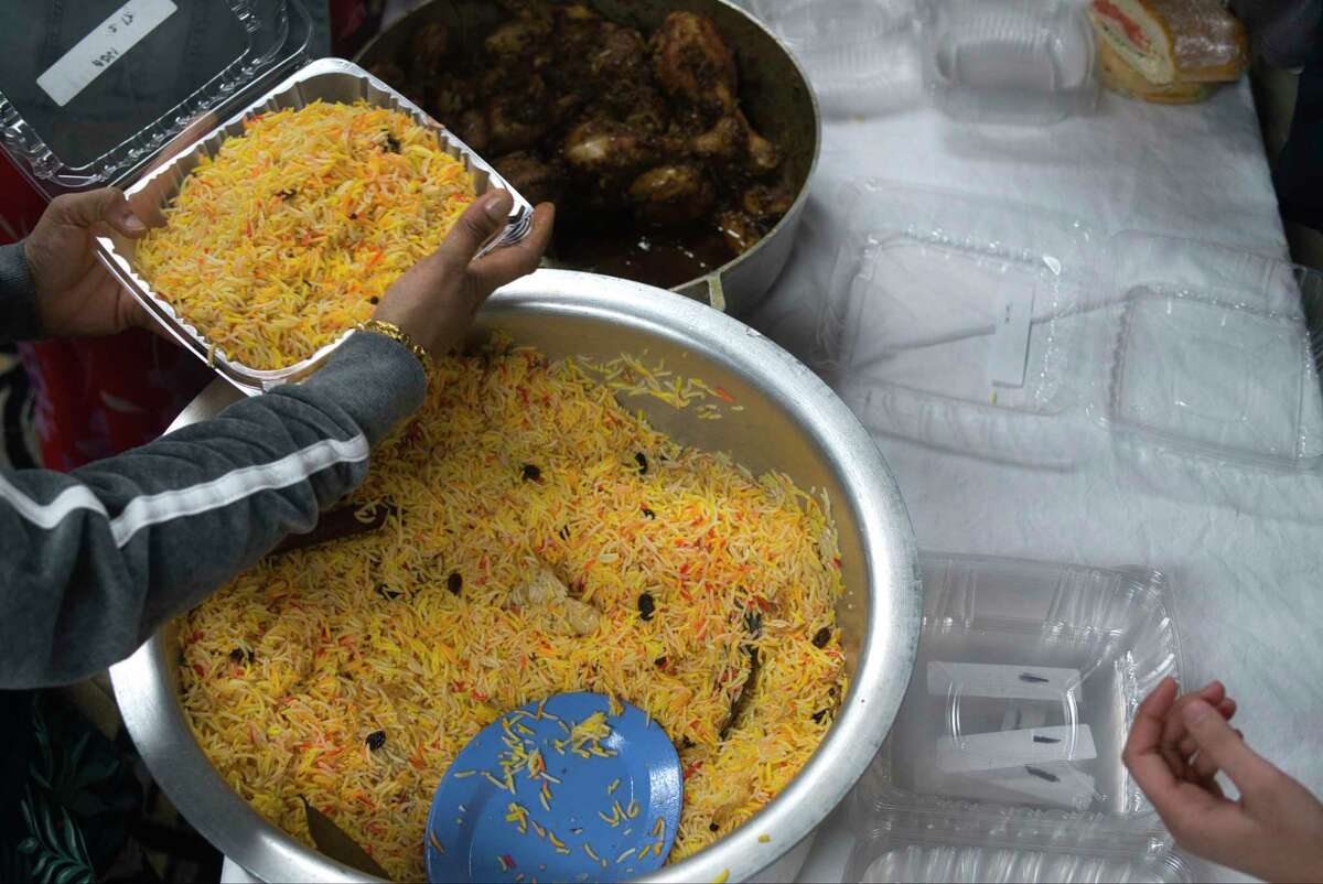 Rice is dished out by volunteers with the Muslim Soup Kitchen as they serve food to Afghan refugees on Sunday, March 7, 2022, at a hotel in Albany, N.Y.