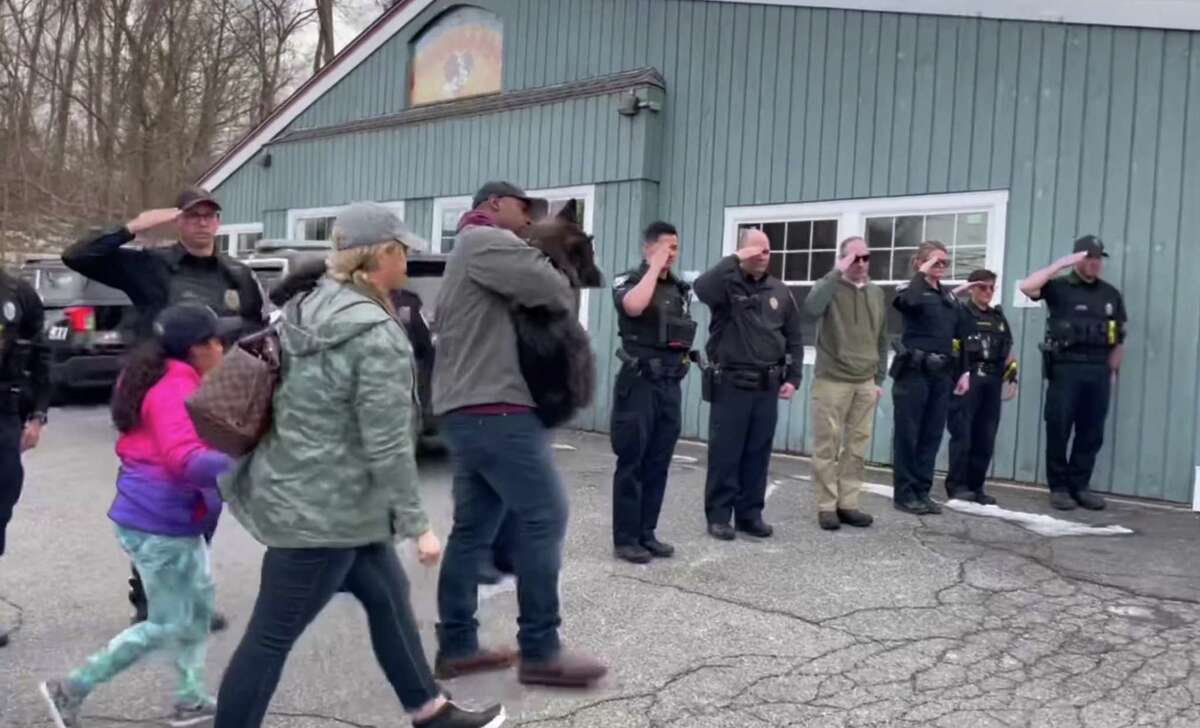 Just months into retirement, K-9 Drake was diagnosed with cancer. Officers salute the former police dog as he’s led into a veterinarian office by his longtime handler, Officer Mark Williams, and his family on Saturday, March 5, 2022.
