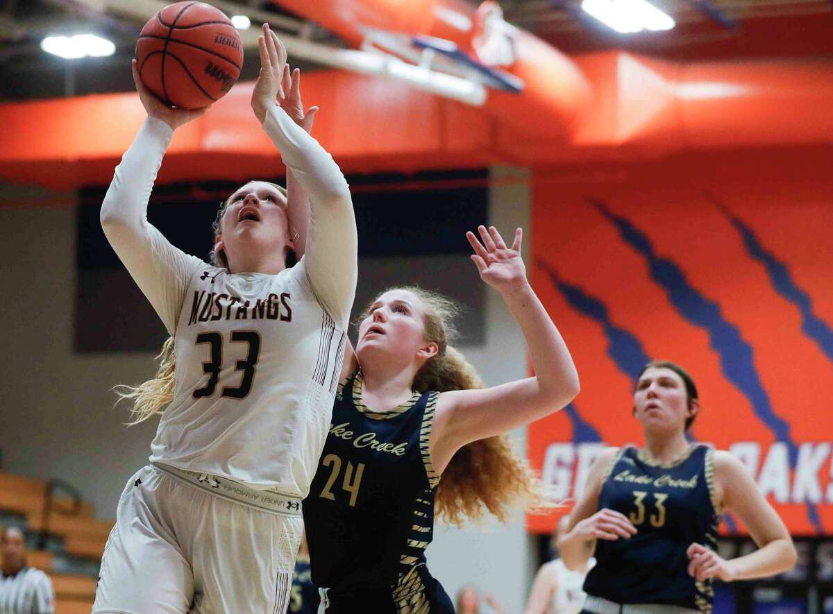 Magnolia West center Cloie Jansky (33) gets a shot past Lake Creek guard Ava Anderson (24) during the fourth quarter of a Region III-5A bi-district high school basketball playoff game at Grand Oak High School, Tuesday, Feb. 15, 2022, in Spring.