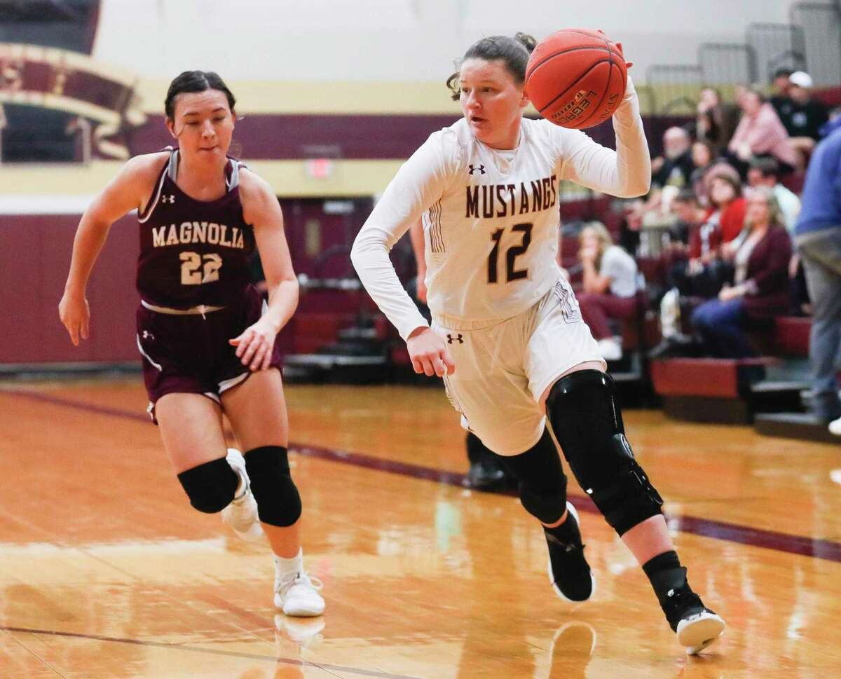 Magnolia West's Megan Donnelly (12) dribbles past Magnolia's Emiley Boone (22) during the first quarter of a high school basketball game at Magnolia West High School, Tuesday, Jan. 4, 2022, in Magnolia.
