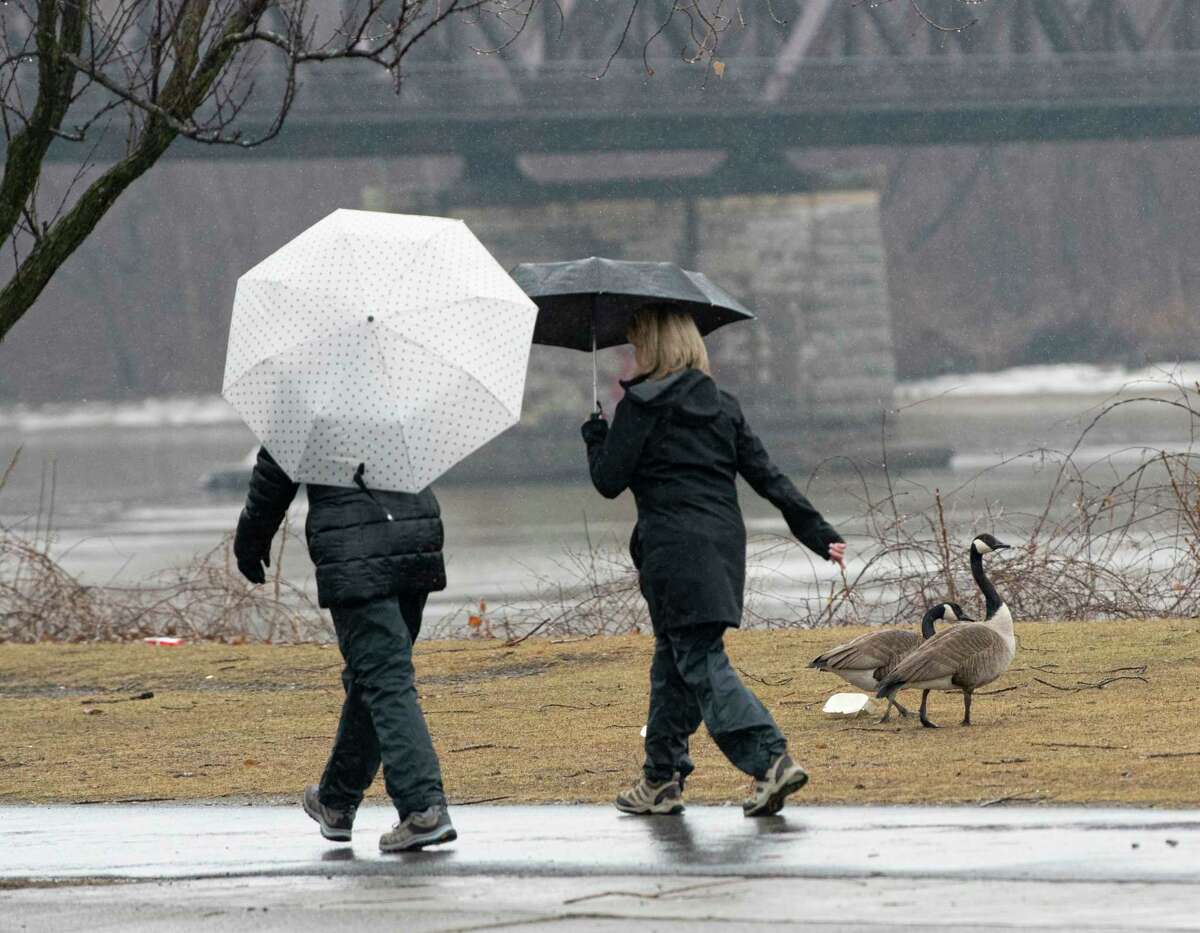 Pedestrians use umbrellas while walking in the rain at the Corning Preserve on Monday, March 7, 2022 in Albany, N.Y.