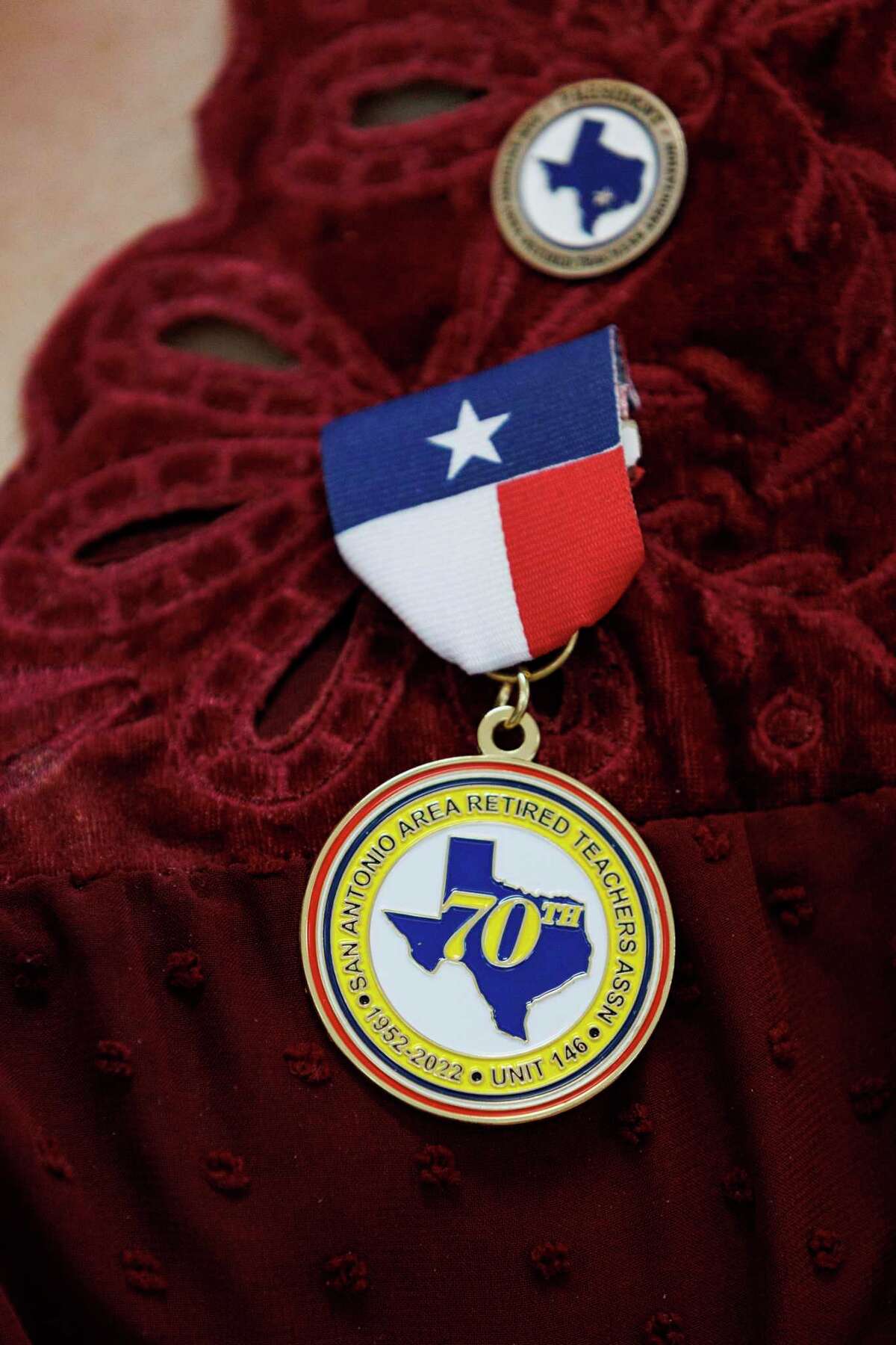 Dr. Norma Smith wears a medal signifying the 70th anniversary of the San Antonio Area Retired Teachers Association, a local chapter of the Texas Retired Teachers Association, during a member meeting at San Antonio Garden Center in San Antonio, Texas, Wednesday, Feb. 16, 2022.