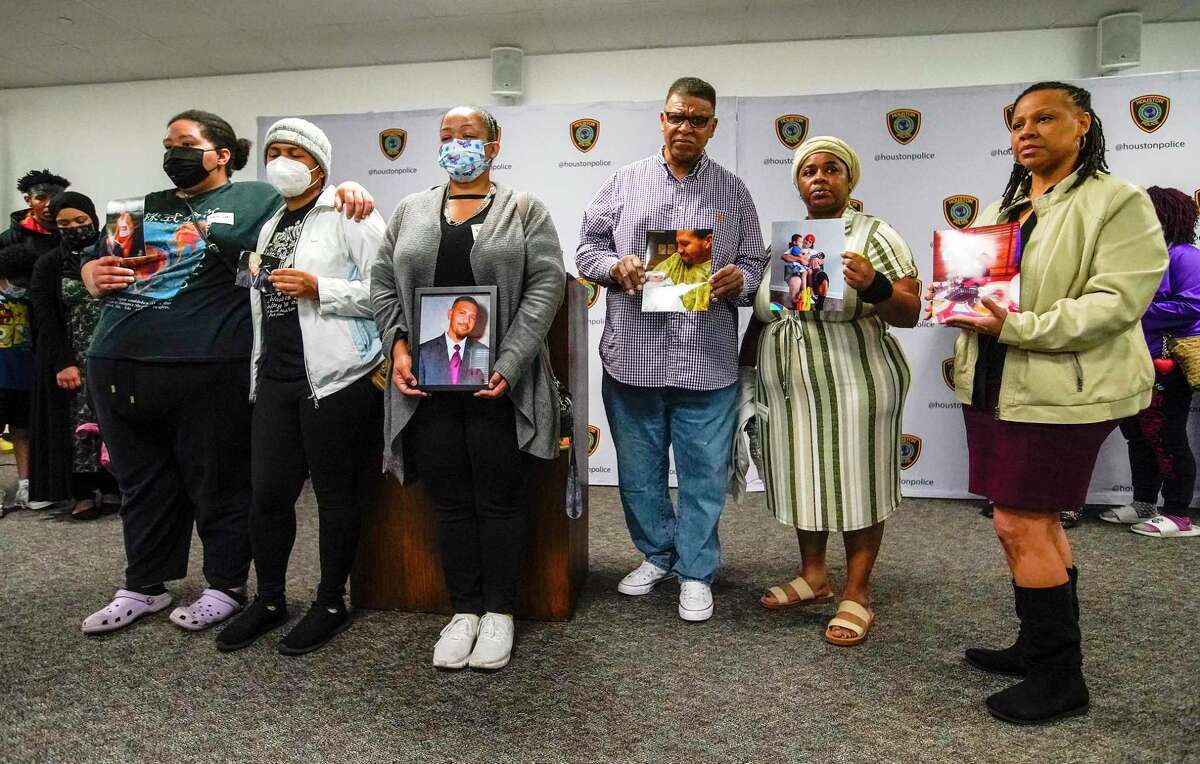 Family members of Clifton Zeno III, 47, hold photos of him at the Houston Police Department’s headquarters Monday.