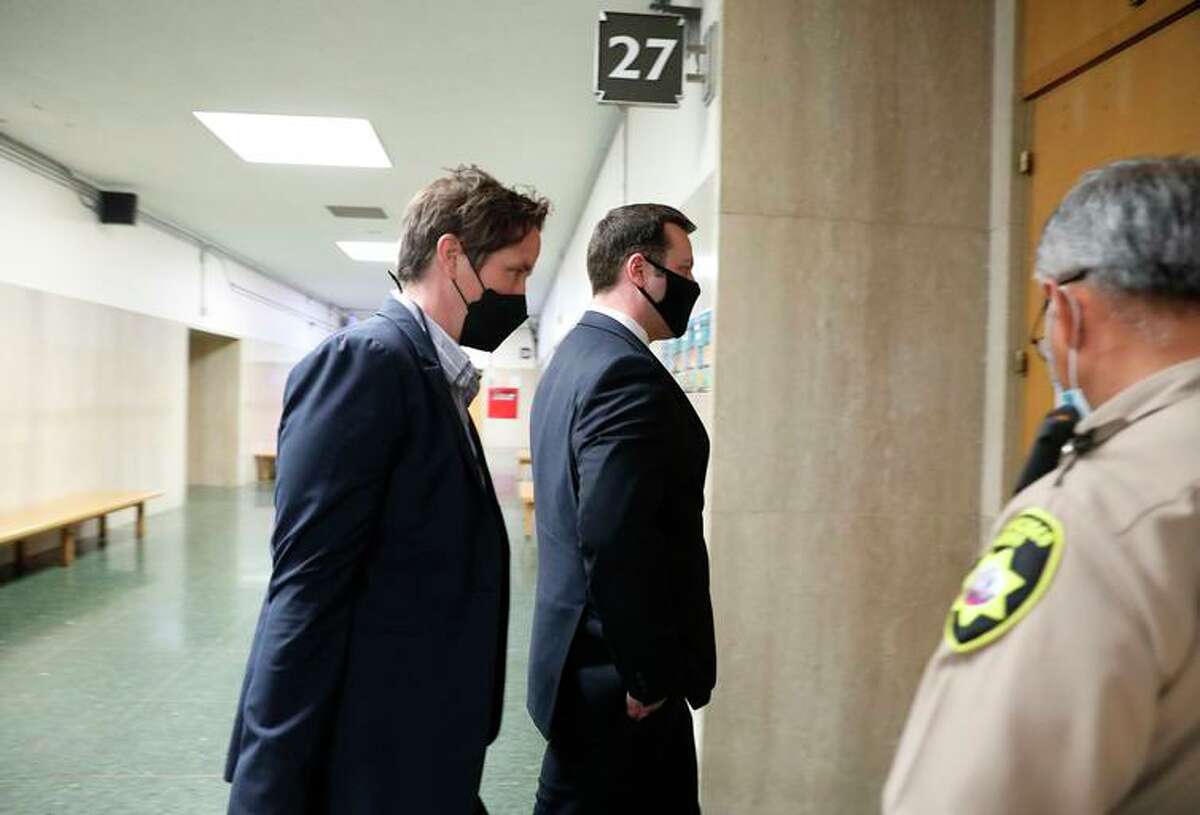 San Francisco Police officer Terrance Stangel (second from the left) enters Department 27 at the Hall of Justice with his attorney Nicole Pifari (left) on Monday, March 7, 2022 in San Francisco, Calif.