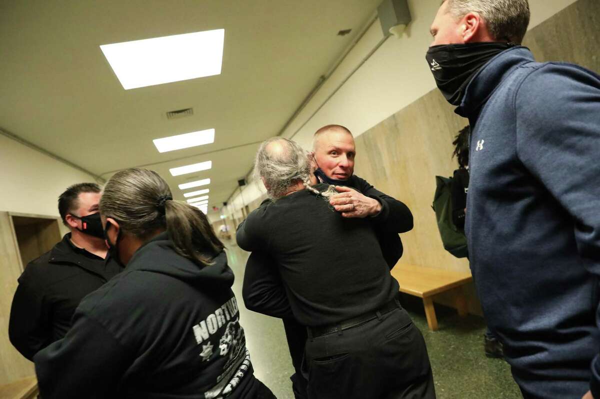 San Francisco Police officer Justin Farrell (second from right) and Kevin Martin, retired San Francisco police officer and assistant legal administrator for San Francisco Police Officers Association (center) embrace after the verdict in the trial of SFPD officer Terrance Stangel at the Hall of Justice on Monday, March 7, 2022 in San Francisco, Calif.