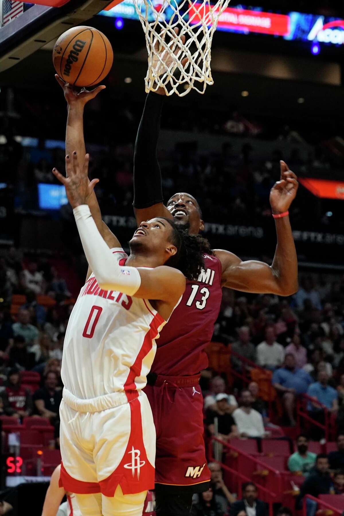 Houston Rockets guard Jalen Green (0) drives to the basket as Miami Heat center Bam Adebayo (13) defends during the first half of an NBA basketball game, Monday, March 7, 2022, in Miami. (AP Photo/Marta Lavandier)