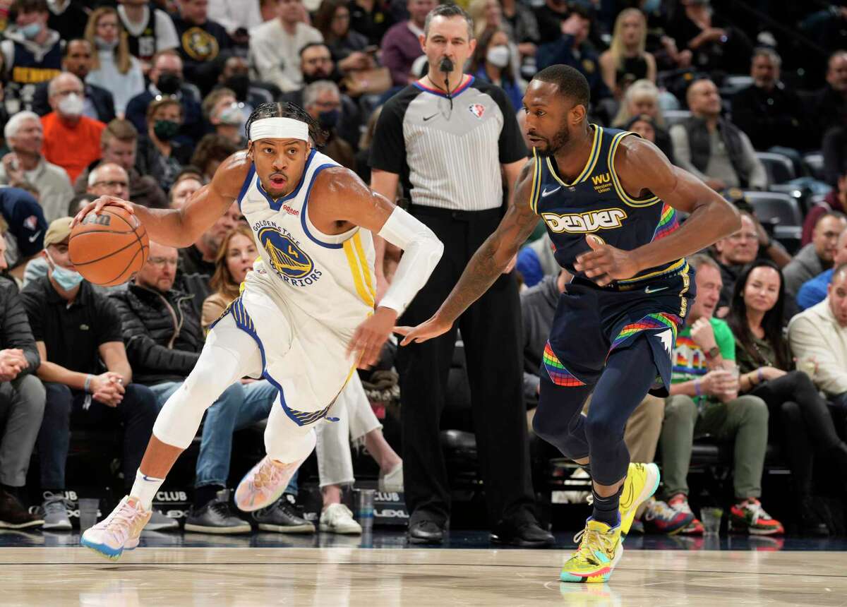 Golden State Warriors guard Moses Moody, left, drives past Denver Nuggets guard Davon Reed in the first half of an NBA basketball game Monday, March 7, 2022, in Denver. (AP Photo/David Zalubowski)