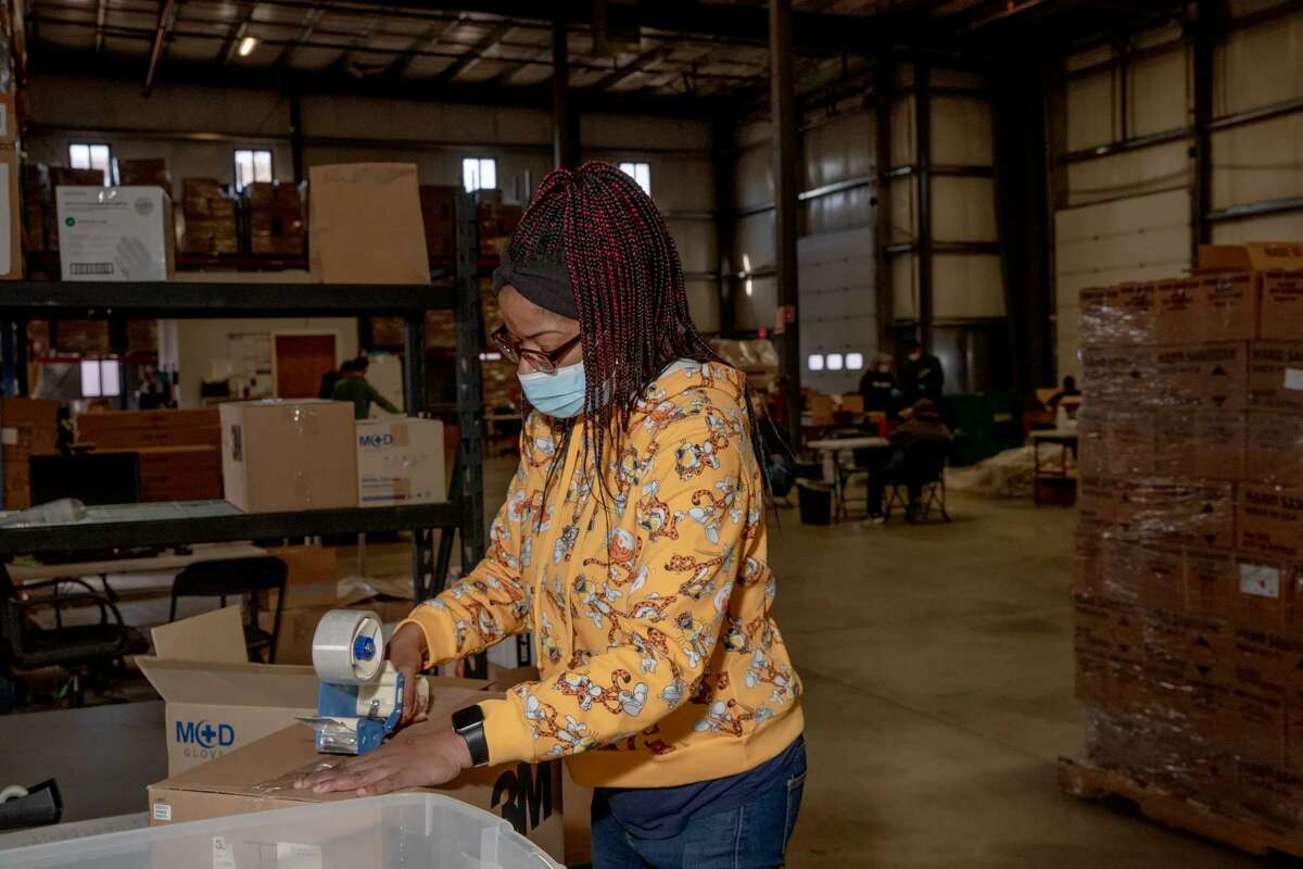 Latasha Jones packs a product to ship out Monday morning at Kennedy Center warehouse in Bridgeport.
