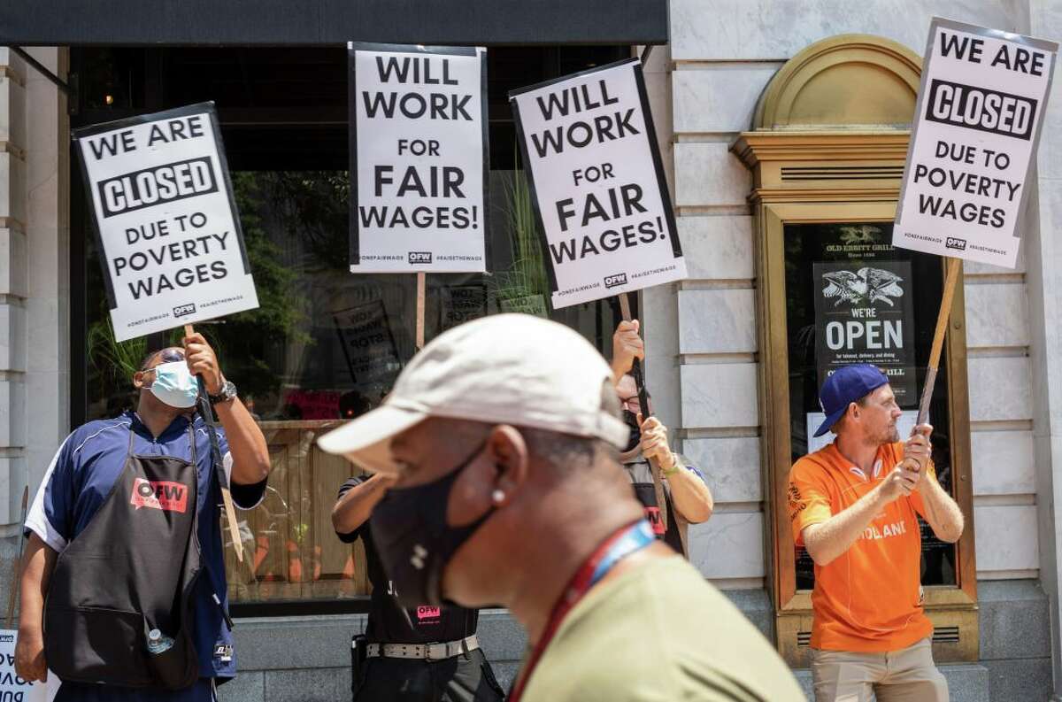 Activists take part in a protest outside of a restaurant calling for full minimum wage. (Photo by Mandel Ngan/AFP via Getty Images)