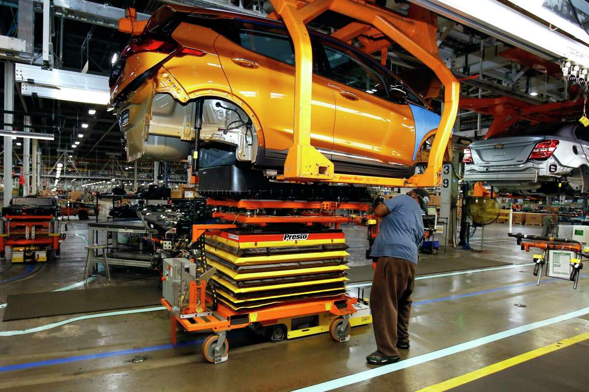 A battery is lifted into place for installation in the Chevrolet Bolt EV at the General Motors Orion Assembly plant in Orion Township, Mich.