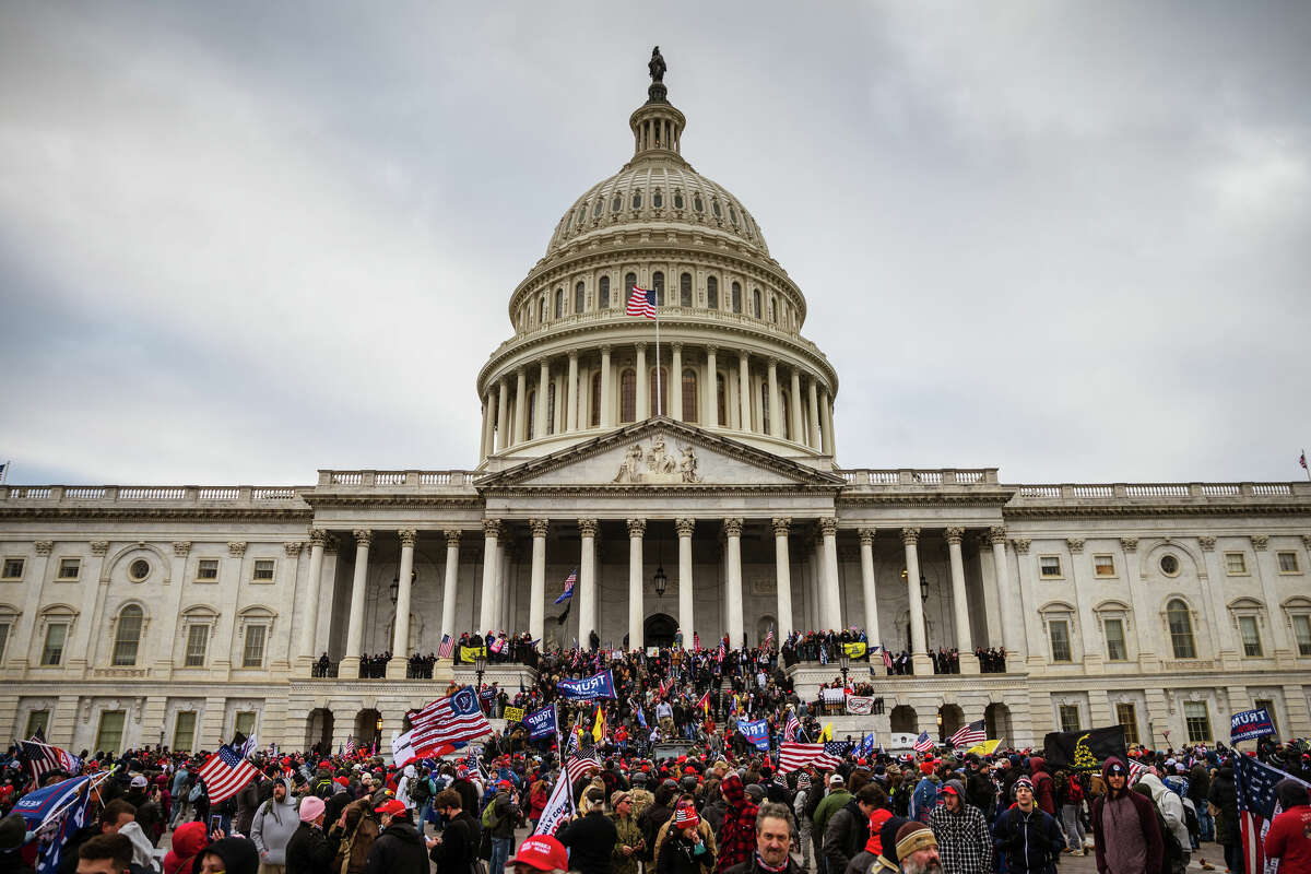 WASHINGTON, DC - JANUARY 06: A large group of pro-Trump protesters stand on the East steps of the Capitol Building after storming its grounds on January 6, 2021 in Washington, DC. A pro-Trump mob stormed the Capitol, breaking windows and clashing with police officers. Trump supporters gathered in the nation's capital today to protest the ratification of President-elect Joe Biden's Electoral College victory over President Trump in the 2020 election. (Photo by Jon Cherry/Getty Images)