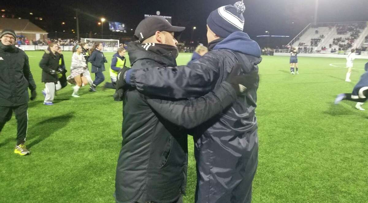 Former Wilton girl soccer coach Renato Topalli, left, hugs Staples coach Barry Beattie after Wilton and Staples played to a 0-0 tie in the Class LL state championship game Nov. 20, 2021. Topalli resigned after six seasons in January.