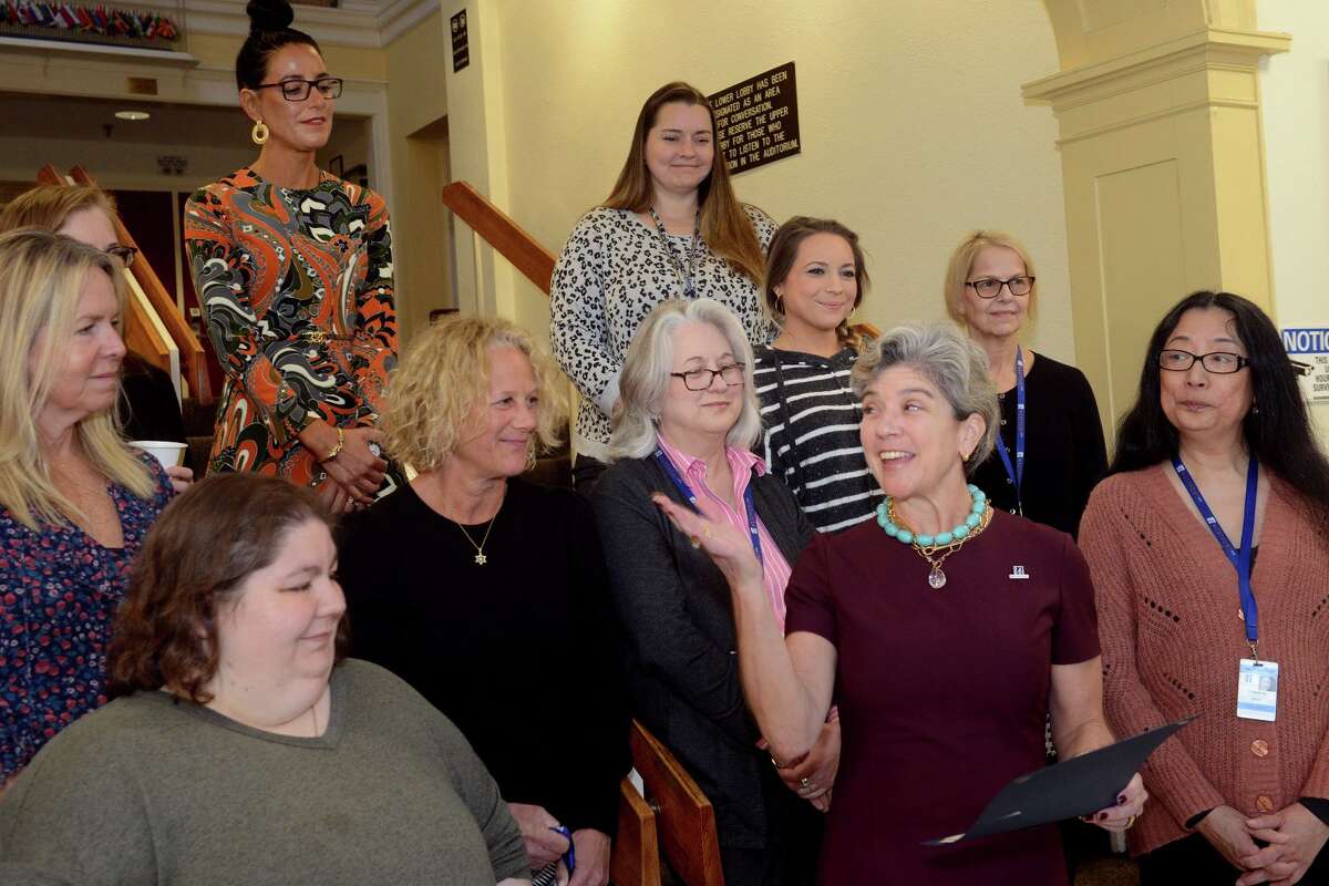 First Selectwoman Jennifer Tooker stands with other women as she reads a proclamation in recognition of International Women’s Day during a reception in the lobby of Town Hall, in Westport, Conn. March 8, 2022.