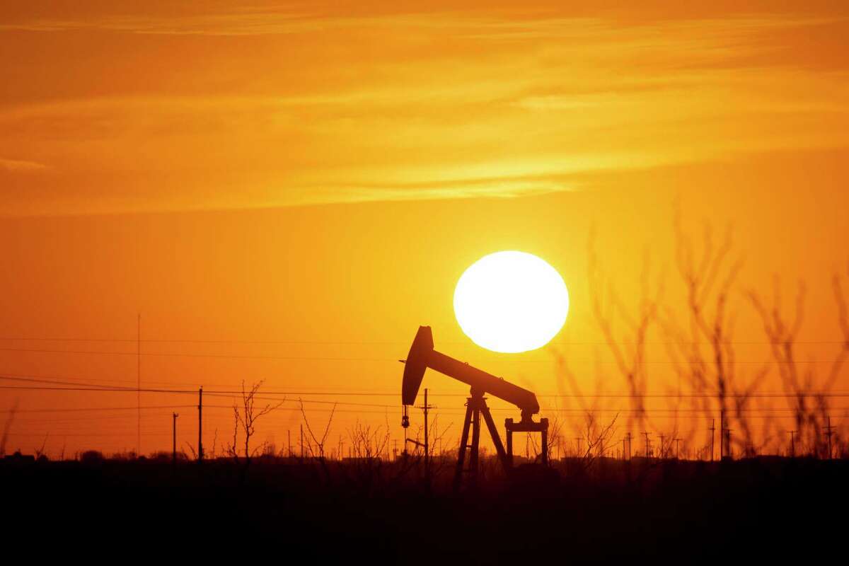 A pump jack operates as the Sun begins to set on the western horizon Monday, March 7, 2022, near Pleasant Farms, an unincorporated community in southeastern Ector County, Texas. Oil prices are rising sharply again Tuesday as the U.S. prepares to ban crude oil imports from Russia in response to that country's unprovoked invasion of neighboring Ukraine. (Jacob Ford/Odessa American via AP)