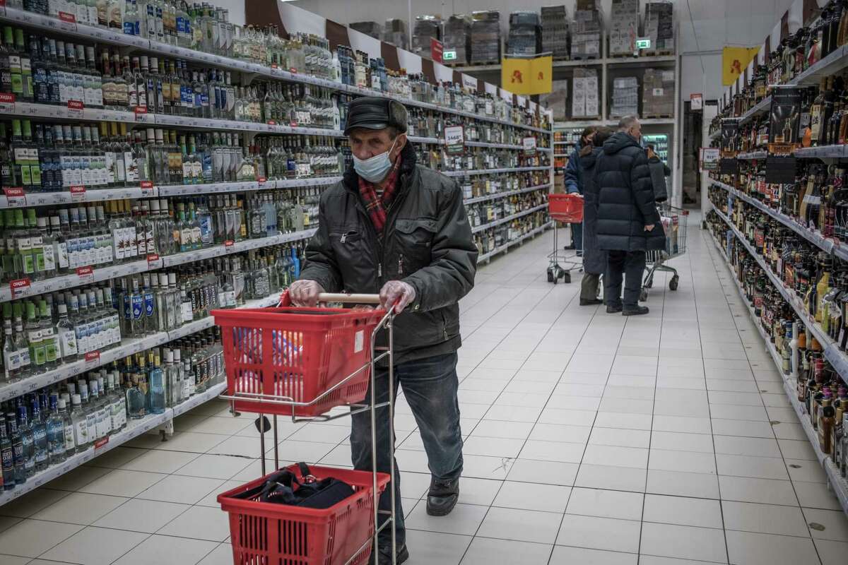People shopping at a supermarket in Moscow, Feb. 28, 2022. The ruble cratered, the stock market froze and the public rushed to withdraw cash on Monday as Western sanctions kicked in and Russia awoke to uncertainty and fear over the rapidly spreading repercussions of President Vladimir Putin’s invasion of Ukraine. (The New York Times)